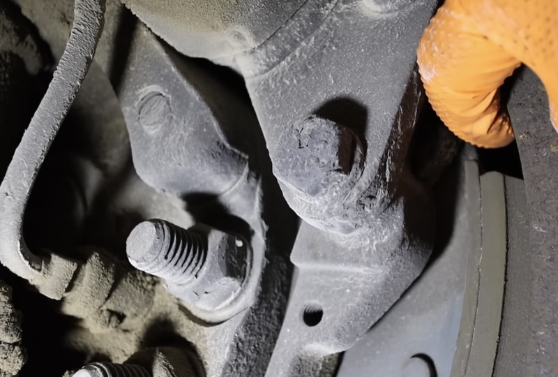 Close-up inspection of a semi truck steering knuckle and king pin